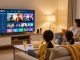Familie nutzt Germany IPTV im gemütlichen Wohnzimmer mit großem Fernseher und Snacks.